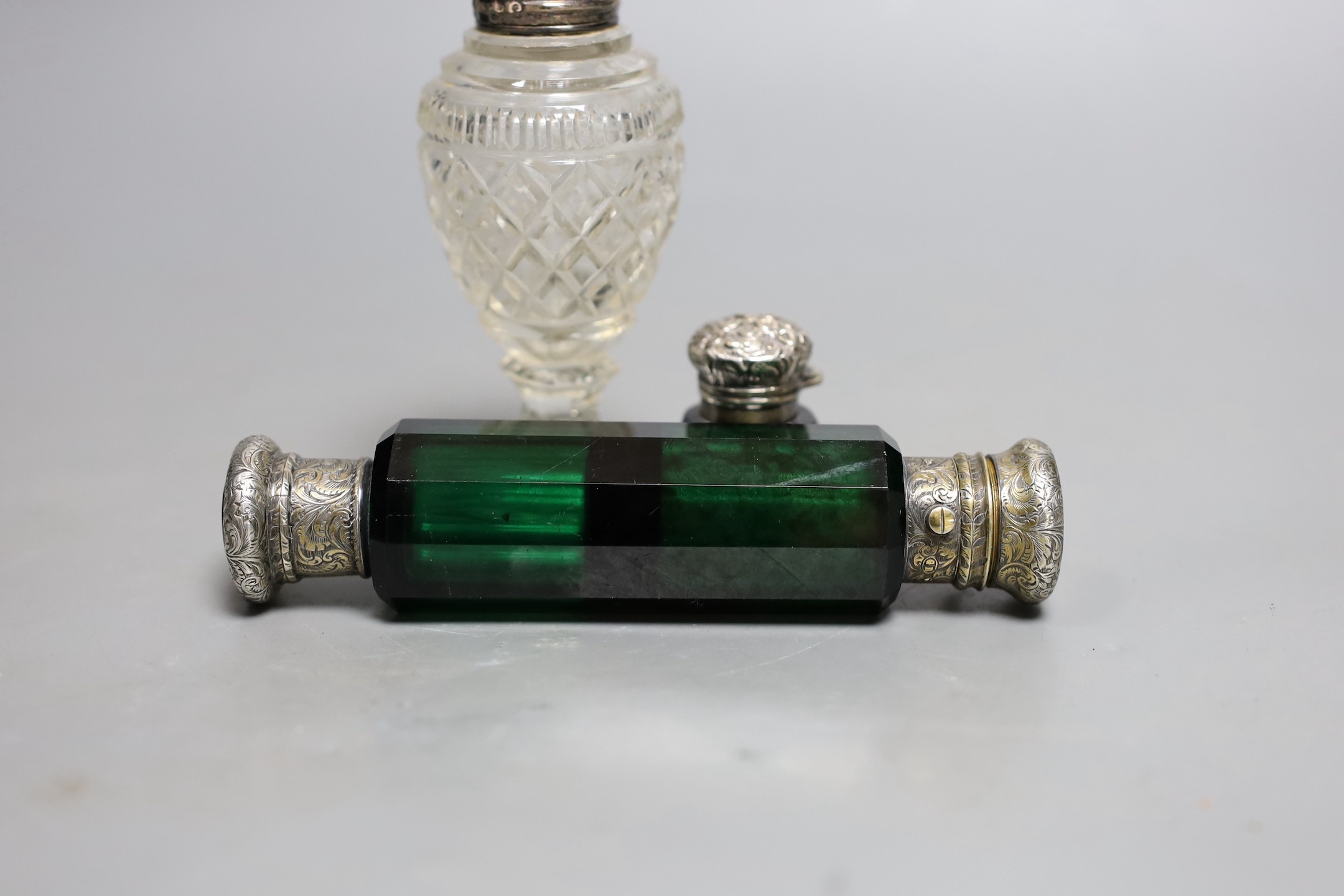 A Victorian silver mounted double ended green glass scent bottle, 13.8cm, a Georgian silver topped cut glass salt and a silver topped blue glass scent bottle (lacking stopper).